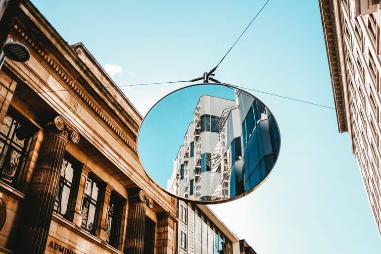 Mirror in street reflecting a building - Cookiebot