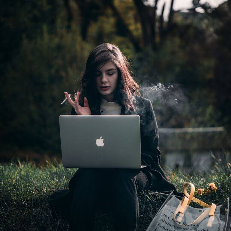 Women sitting outside looking at laptop - Cookiebot